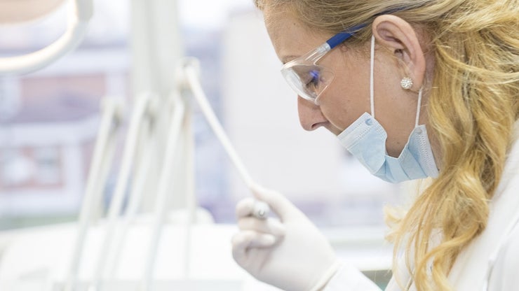 Side view of a dentist holding a tool