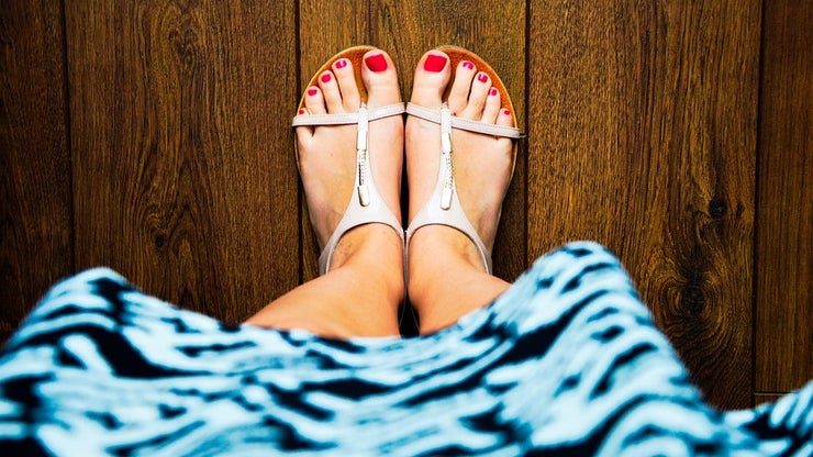 Feet wearing sandals with red painted toenails