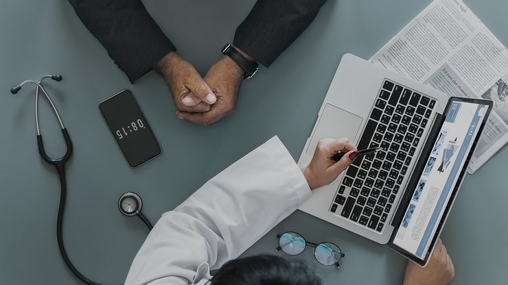 Doctor meeting with a patient in front of a laptop