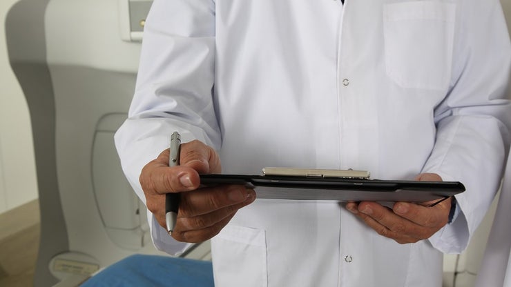 Doctor in a white coat holding a tablet